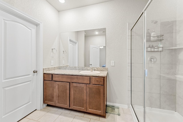 bathroom featuring vanity, a shower with door, and tile patterned floors