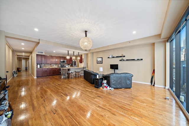 living room with a chandelier and light wood-type flooring