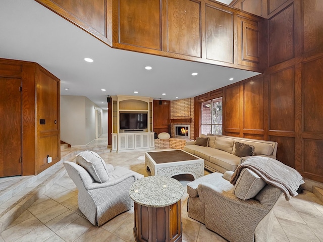 living room featuring a brick fireplace and wood walls