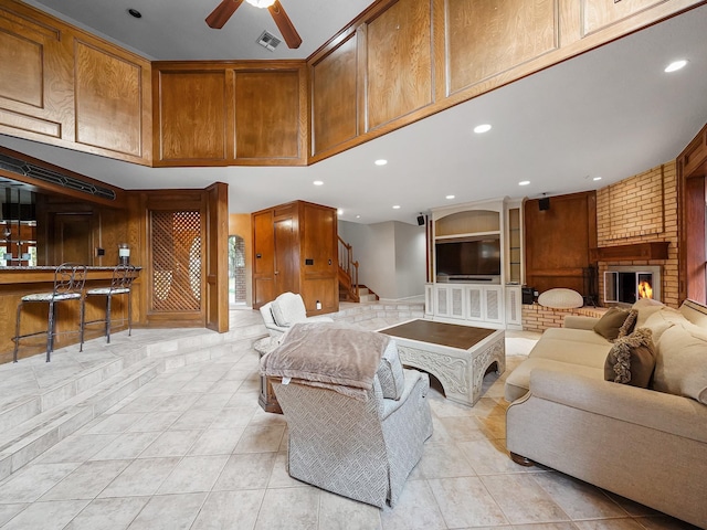 living room with light tile patterned floors, a fireplace, and ceiling fan