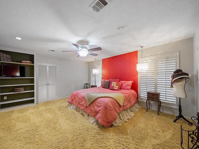 bedroom featuring ceiling fan, carpet, and a textured ceiling