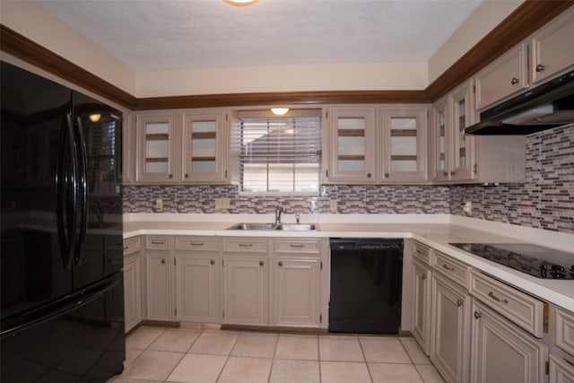 kitchen featuring sink, a textured ceiling, light tile patterned floors, decorative backsplash, and black appliances