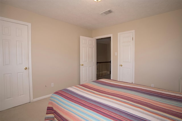 bedroom with light carpet and a textured ceiling