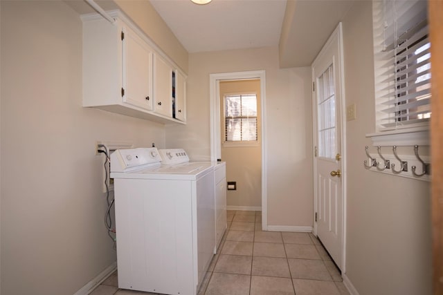 laundry room featuring separate washer and dryer, cabinets, and light tile patterned flooring