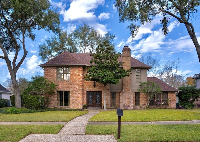 view of front of property with french doors and a front lawn