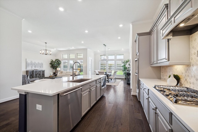 kitchen featuring sink, custom exhaust hood, appliances with stainless steel finishes, gray cabinets, and an island with sink