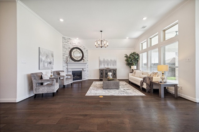 living room featuring lofted ceiling, a large fireplace, dark hardwood / wood-style flooring, a notable chandelier, and crown molding