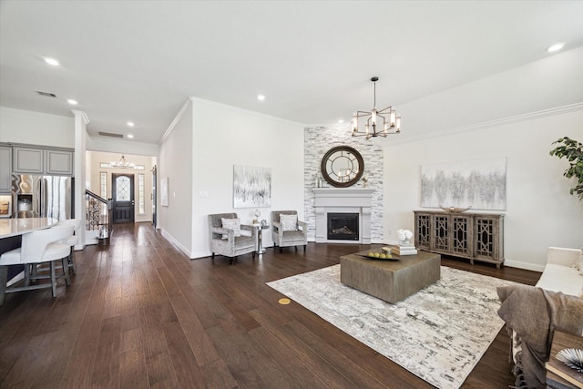 living room featuring dark wood-type flooring, a fireplace, and a chandelier