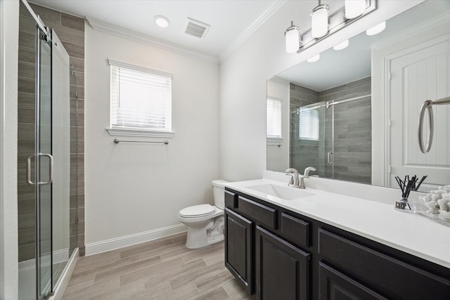 bathroom featuring crown molding, vanity, toilet, and a wealth of natural light