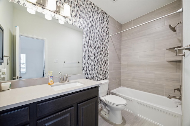 full bathroom featuring vanity, tile patterned floors, toilet, and tiled shower / bath