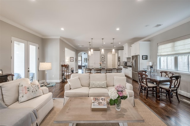 living room with crown molding, wood-type flooring, french doors, and a wealth of natural light