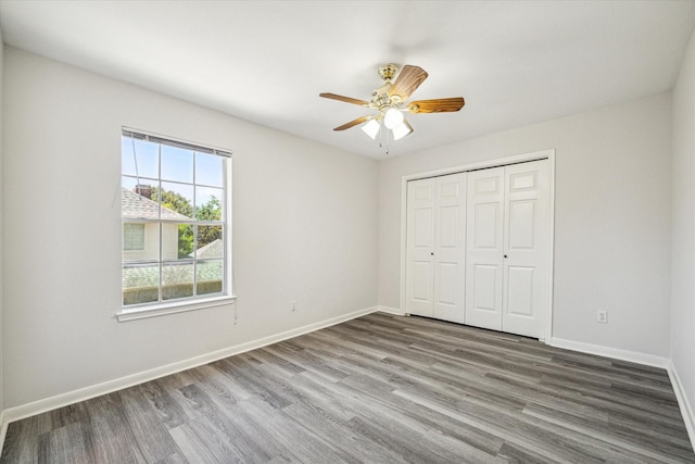 unfurnished bedroom featuring hardwood / wood-style flooring, a closet, and ceiling fan