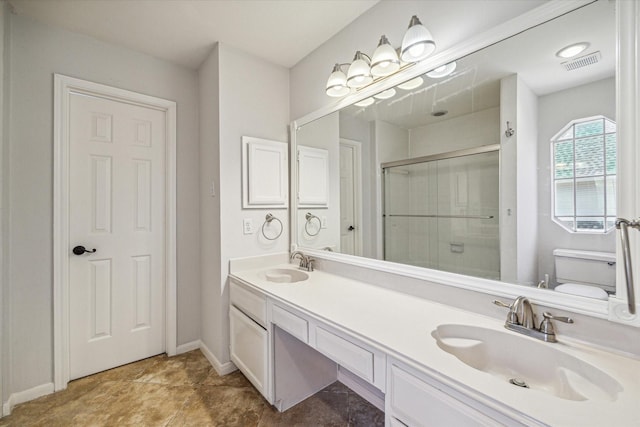 bathroom with vanity, a shower with shower door, and toilet