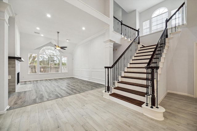 unfurnished living room with crown molding, plenty of natural light, ceiling fan, and light wood-type flooring