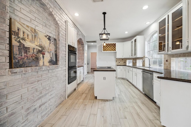 kitchen featuring decorative light fixtures, sink, a center island, stainless steel dishwasher, and a healthy amount of sunlight