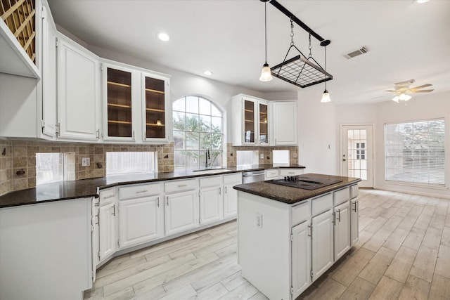 kitchen with black electric cooktop, a center island, decorative backsplash, and white cabinets