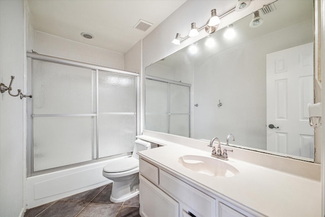 full bathroom featuring vanity, combined bath / shower with glass door, tile patterned floors, and toilet