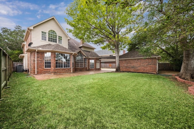 rear view of property with a yard, central AC unit, and a patio area