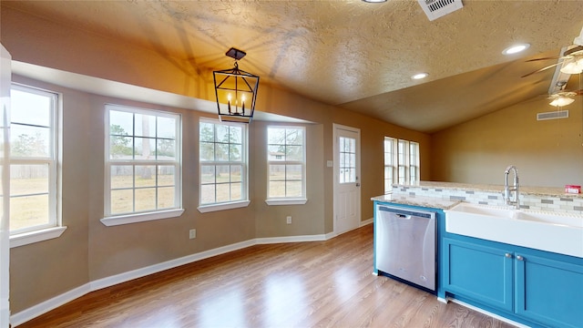 kitchen with blue cabinets, vaulted ceiling, stainless steel dishwasher, pendant lighting, and decorative backsplash