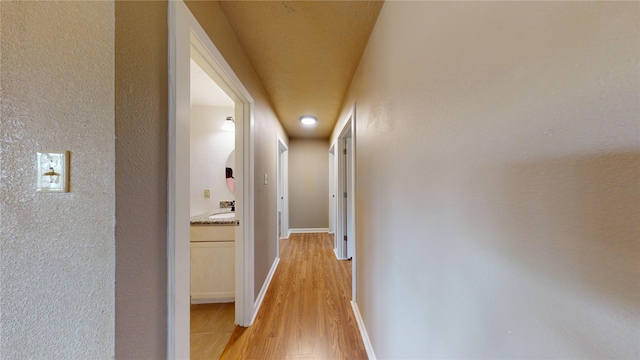 hall featuring sink and light hardwood / wood-style floors