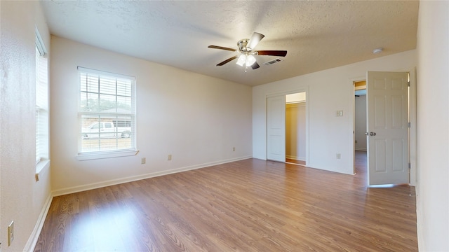 spare room featuring ceiling fan, hardwood / wood-style flooring, and a textured ceiling