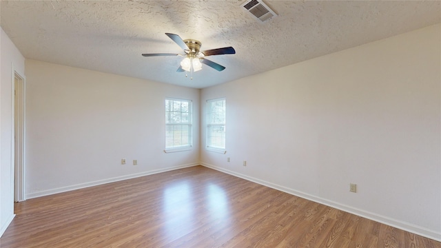 unfurnished room with ceiling fan, light hardwood / wood-style floors, and a textured ceiling