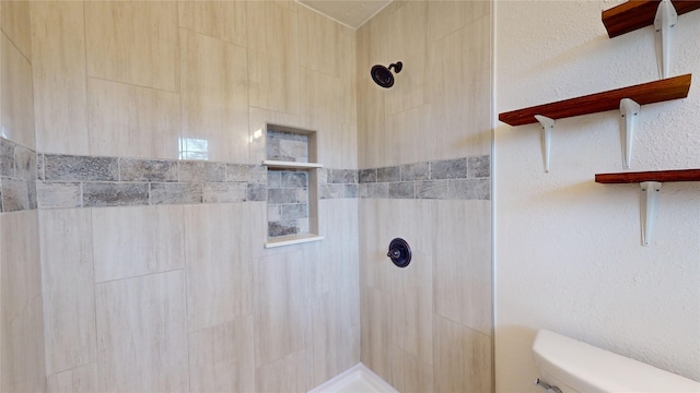 bathroom with toilet and a tile shower