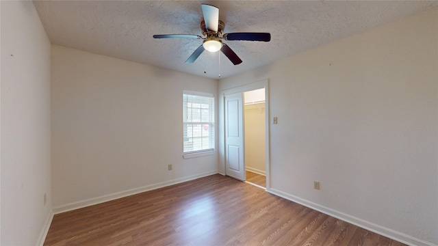 unfurnished room featuring ceiling fan, a textured ceiling, and light wood-type flooring