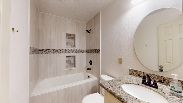 full bathroom featuring vanity, tiled shower / bath, toilet, and a textured ceiling