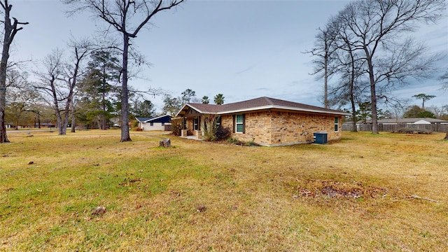 view of side of home with central AC and a lawn