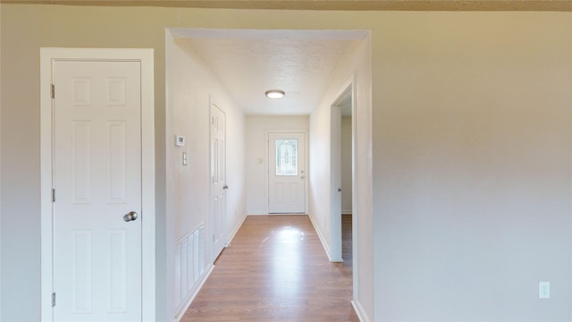 corridor featuring hardwood / wood-style flooring and a textured ceiling