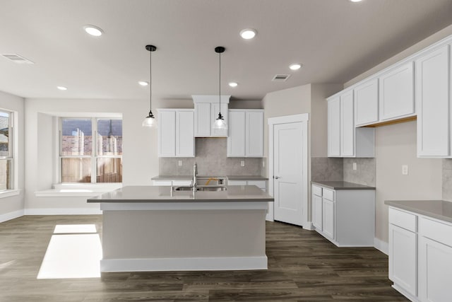 kitchen featuring dark hardwood / wood-style flooring, sink, white cabinets, and a center island with sink