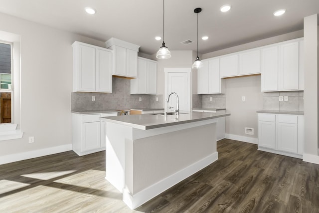 kitchen with a kitchen island with sink, sink, white cabinets, and dark hardwood / wood-style floors