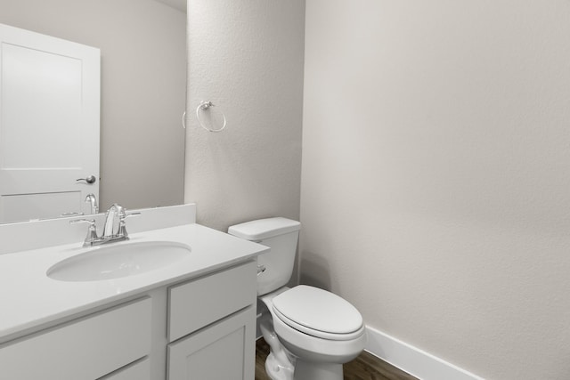 bathroom with vanity, wood-type flooring, and toilet