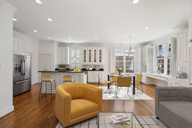 living room featuring crown molding, a healthy amount of sunlight, and light hardwood / wood-style floors