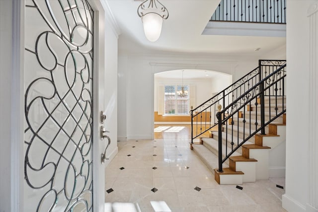 tiled foyer entrance featuring crown molding