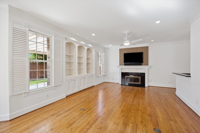 unfurnished living room featuring ceiling fan, plenty of natural light, built in features, and light wood-type flooring