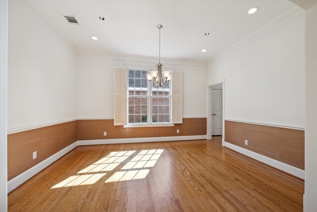 unfurnished dining area featuring ornamental molding, light hardwood / wood-style floors, and a notable chandelier