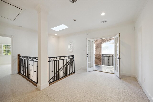 interior space with french doors, light colored carpet, and crown molding