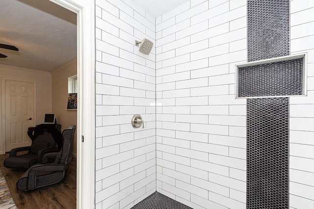 bathroom featuring a tile shower and wood-type flooring