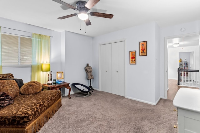 living area with light carpet and ceiling fan