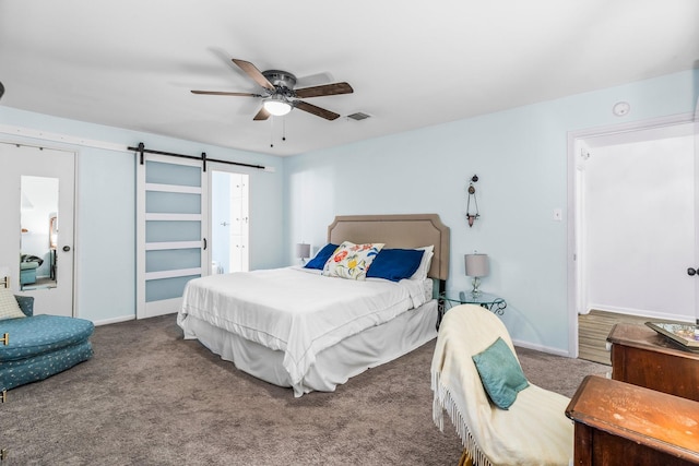 carpeted bedroom featuring a barn door and ceiling fan