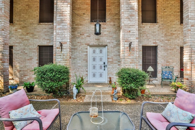 view of exterior entry featuring a patio area