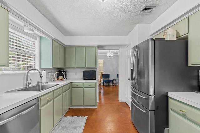 kitchen featuring green cabinetry, stainless steel appliances, sink, and a textured ceiling