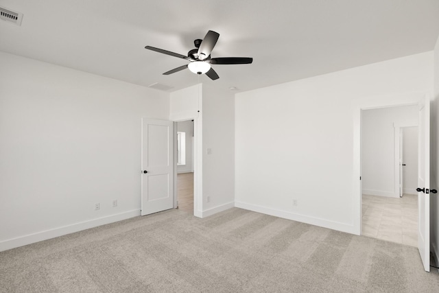 spare room with ceiling fan and light colored carpet