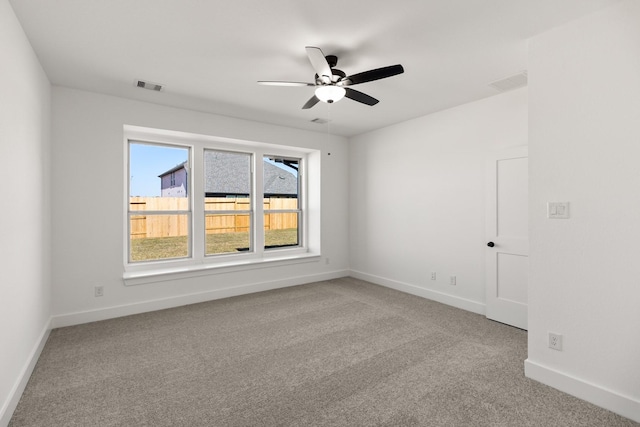 carpeted spare room featuring ceiling fan