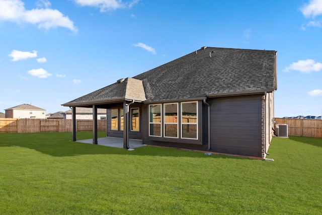 rear view of house with central AC unit, a lawn, and a patio