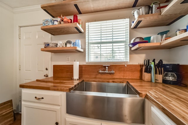 5411 Pecan St, Crosby, TX 77532 - kitchen featuring crown molding, sink, white cabinets, and wood counters