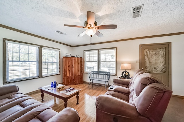 5411 Pecan St, Crosby, TX 77532 - living room with ceiling fan, ornamental molding, light hardwood / wood-style floors, and a textured ceiling