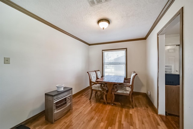 5411 Pecan St, Crosby, TX 77532 - dining room featuring ornamental molding, light hardwood / wood-style floors, and a textured ceiling
